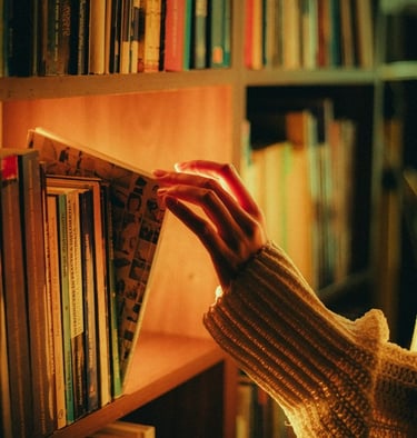 Cinematic image of a female hand taking a book out of the shelf