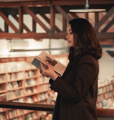 Photo of an elegant woman reading a book in a bookstore
