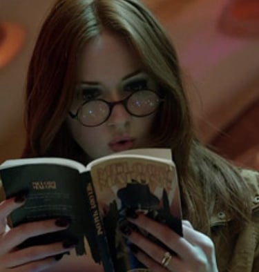 imagem da personagem amy pond da serie doctor who lendo um livro dentro da tardis.