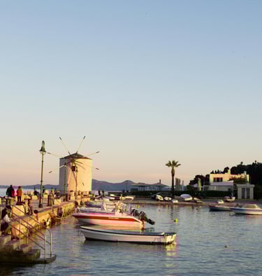 a boat is docked at a pier with people walking on the water