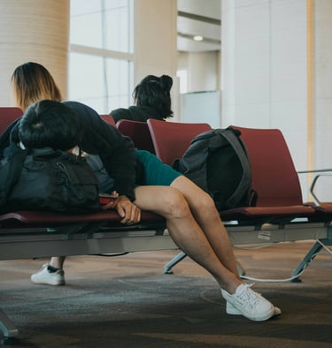 woman lying on a airport bench
