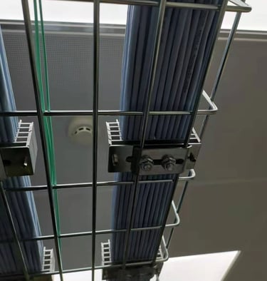 un chemin de câbles en treillis métallique avec plusieurs fils et un dispositif de fixation de câble