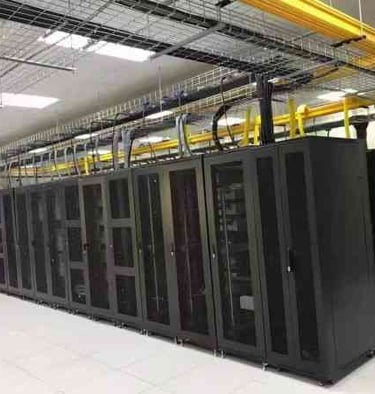 a large machien room with yellow fiber cable trays and wire mesh cable trays