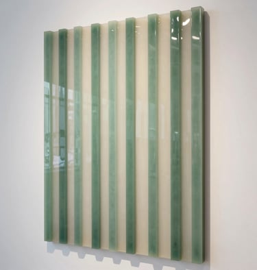 A vertical resin panel with vertical Sage Green and Almond White stripes, hanging in a bright, modern International / Global gallery.