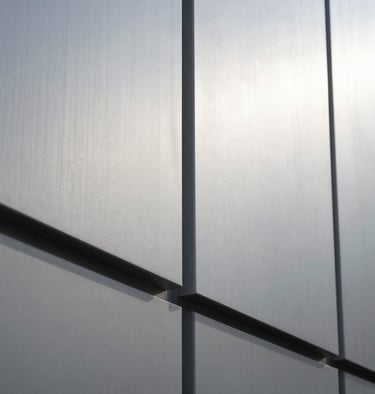 Abstract architectural shot focusing on light and shadow on a light silver wall, minimalist and contemporary.