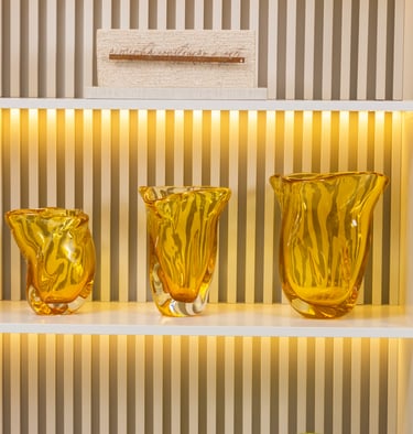 a shelf with three vases and a plant in the middle