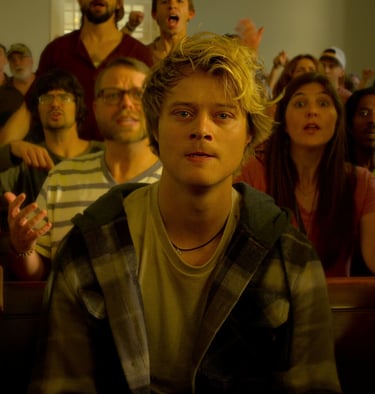 a man in a church pewing chair with a woman in a crowd of people