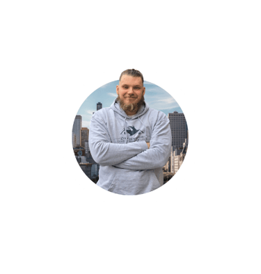 Zynel Bartosz, directeur de Zynel Rénovation, posant bras croisés devant un fond urbain, garant de l