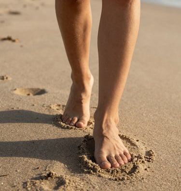 Detail shot of feet walking on a North American / US beach, soft sand textures, warm golden light, cinematic style.