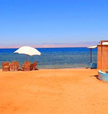 Plage avec chaises longues et parasol avec vue sur la mer Rouge en Égypte