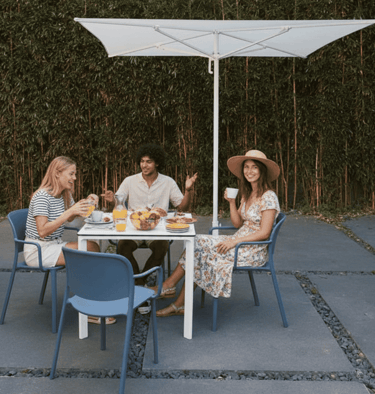 Espacio corporativo de bienestar con sillones, plantas y personas trabajando en pausa.