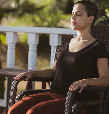 a woman sitting on a chair with her eyes closed
