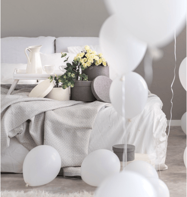 bedroom with subtle hues of linen  with balloons 