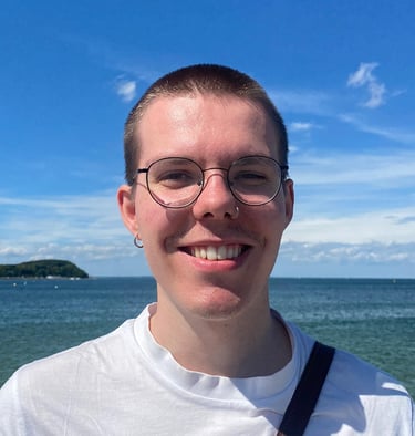 A photo of me smiling and standing in front of a sea