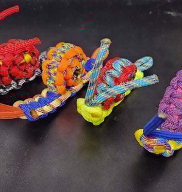 Four colorful paracord snails lined up next to each other