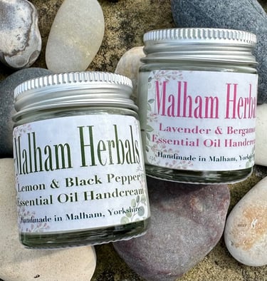Jars of essential oil hand cream in a natural setting