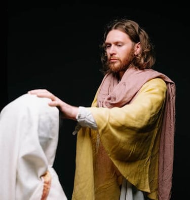 a man laying hand on a woman in a robe