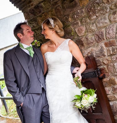 Photograph of a man and woman, looking happy on their wedding day. 