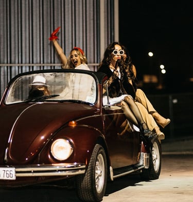 a group of dancers entering the venue in a vintage car during an event photoshoot in Malta