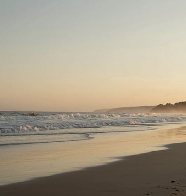 Poetic minimalist landscape of a quiet South American beach at golden hour, soft waves reflecting alabaster and muted gold sky. Calm, introspective mood, high fashion travel editorial feel.