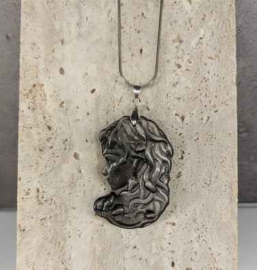 Handcrafted Silver Obsidian pendant necklace displayed on a textured stone background.