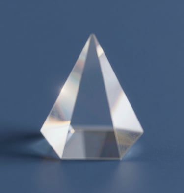 Abstract shot of light refracting through a crystal prism, creating soft flares of #F2F5F7 against a deep blue #4A616F background.