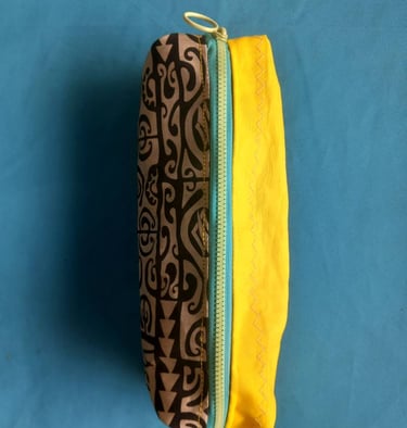 Handmade fabric zipper pouch featuring a brown tribal print pattern and bright yellow lining.