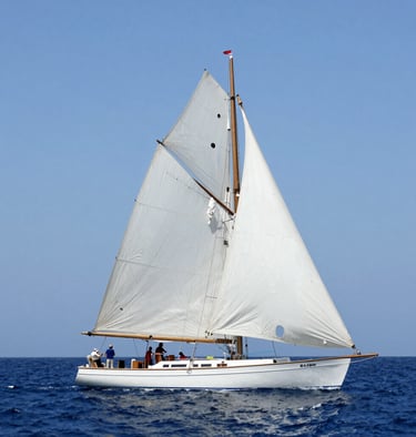 A sleek white sailboat gliding on calm blue waters under a clear sky.