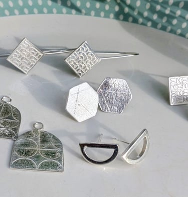 Handmade textured sterling silver earrings in geometric shapes.
