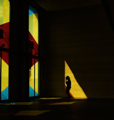 silhouette d'une femme dans le hall d'une gare aux fenêtres colorées