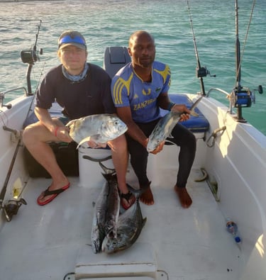 Tourist and local fisherman on a boat with their fresh catches during a Zanzibar fishing game