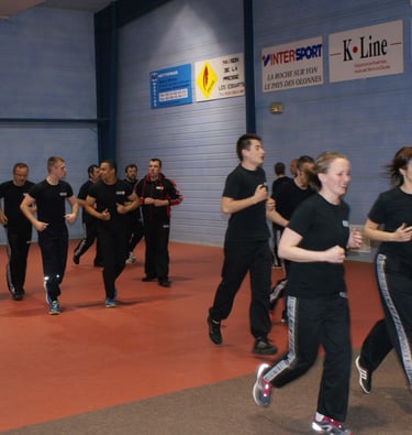 a group of people in black shirts and black pants, running and practice krav maga