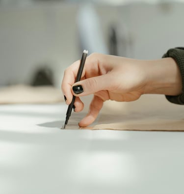 a person holding a pen and writing on a paper