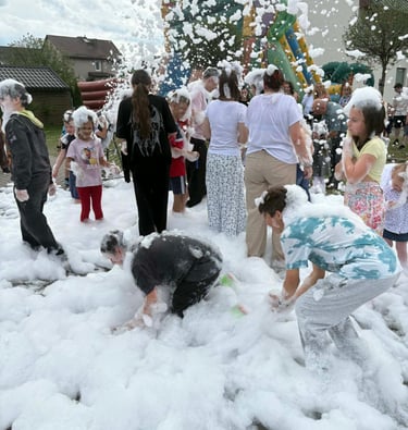 a group of people playing in a foamy foam filled with foam