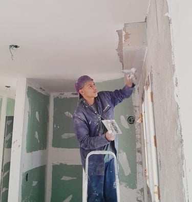 Homem passando gesso liso nas paredes