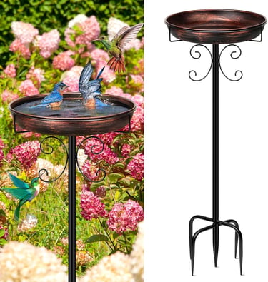 A decorative copper bird bath on a black metal stand with hummingbirds and bluebirds in a flower garden.