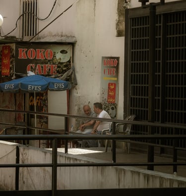Two men sit outside Beirut Cafe in a local street scene beirut Lebanon Photographer and photography