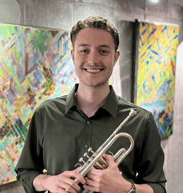Ben Van Wienen in a green shirt holding his trumpet
