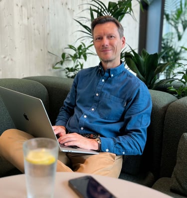 Andreas Frank, Interim CFO, sitzt mit Laptop in entspannter Arbeitsatmosphäre