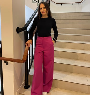 Mulher usando uma calça pantalona  rosa e blusa preta