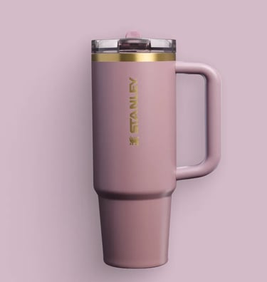 a pink Stanley mug with a gold rim and a pink mug