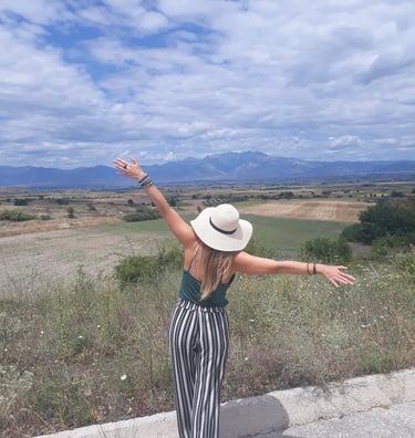 Martina with arms open in a field in Bulgaria.
