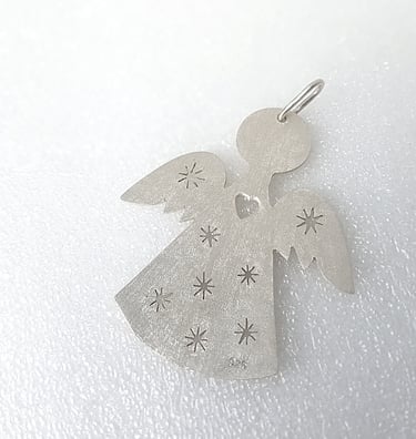 a silver angel with stars on a white surface