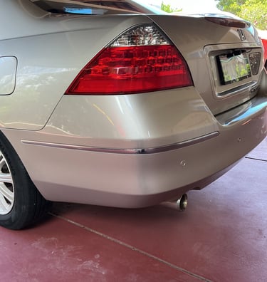 Rear view of a silver Honda Accord showing freshly refinished taillight, bumper, and exhaust pipe.