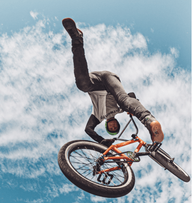 a man doing a trick on a bicycle