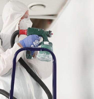 Pintor profesional aplicando pintura en la pared con airless.