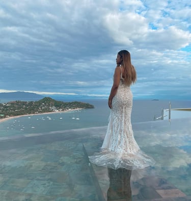 a woman in a white dress standing on a glass table