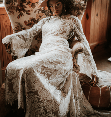 a woman in a white dress and hat sitting on a chair