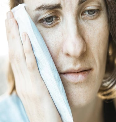 a woman with a towel on her head, in pain
