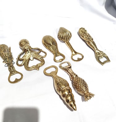 a bunch of gold colored metal objects on a white surface